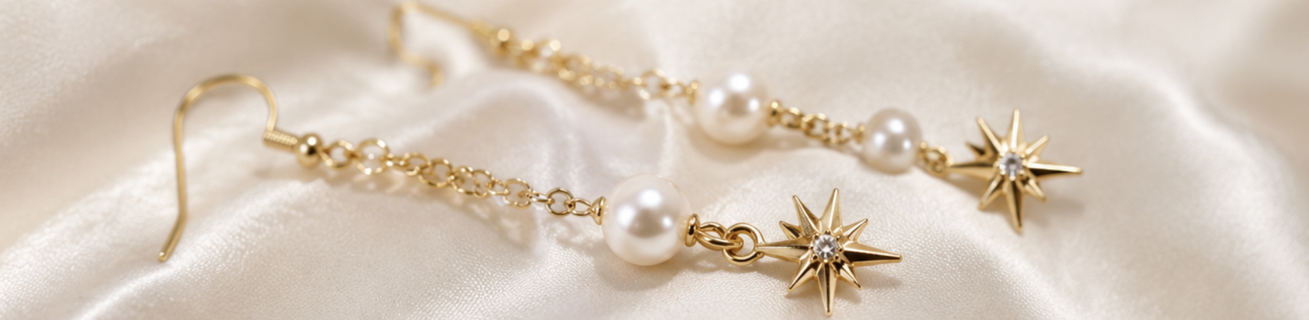 Gold star and pearl dangle earrings on ivory silk
